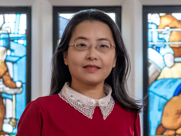 Portrait of Diwei Zhou against a stained glass window