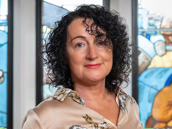 A portrait photograph of Fran Selby against a stained glass background