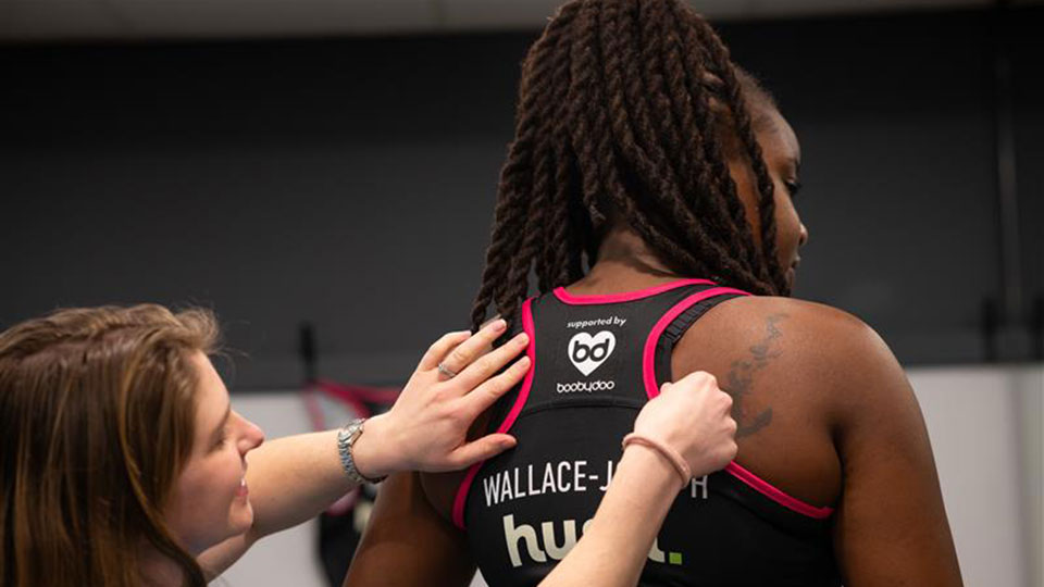 The back of a netball player having their back measured for a sports bra fitting