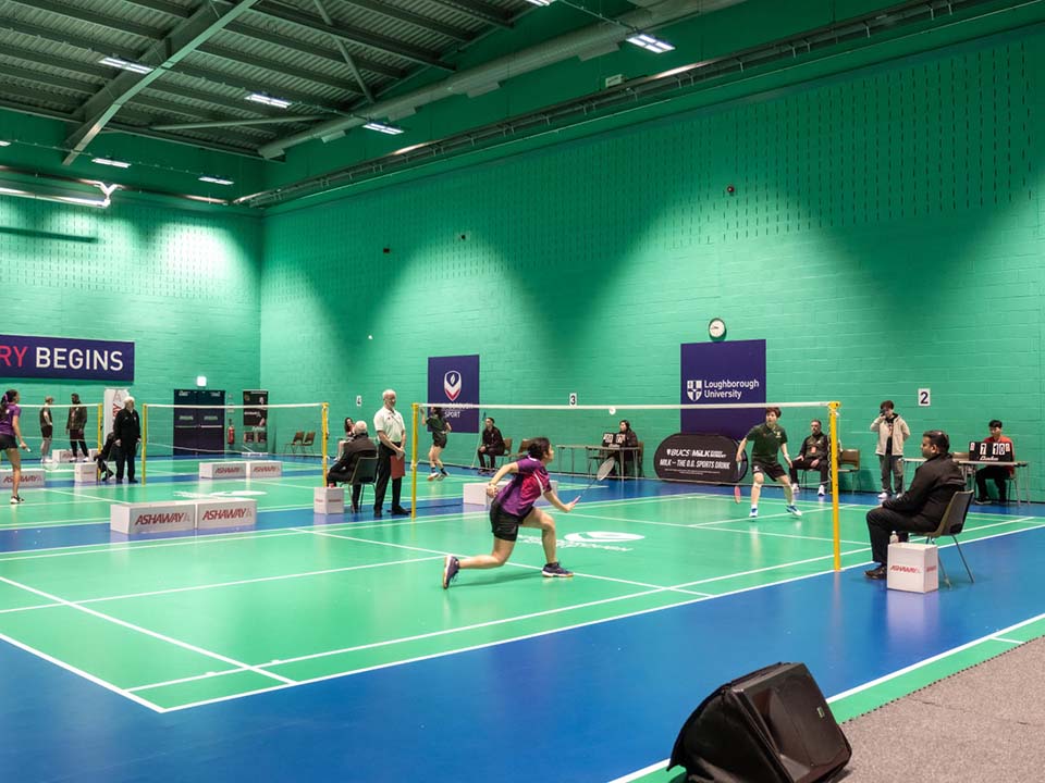 The hall is set up for badminton games.