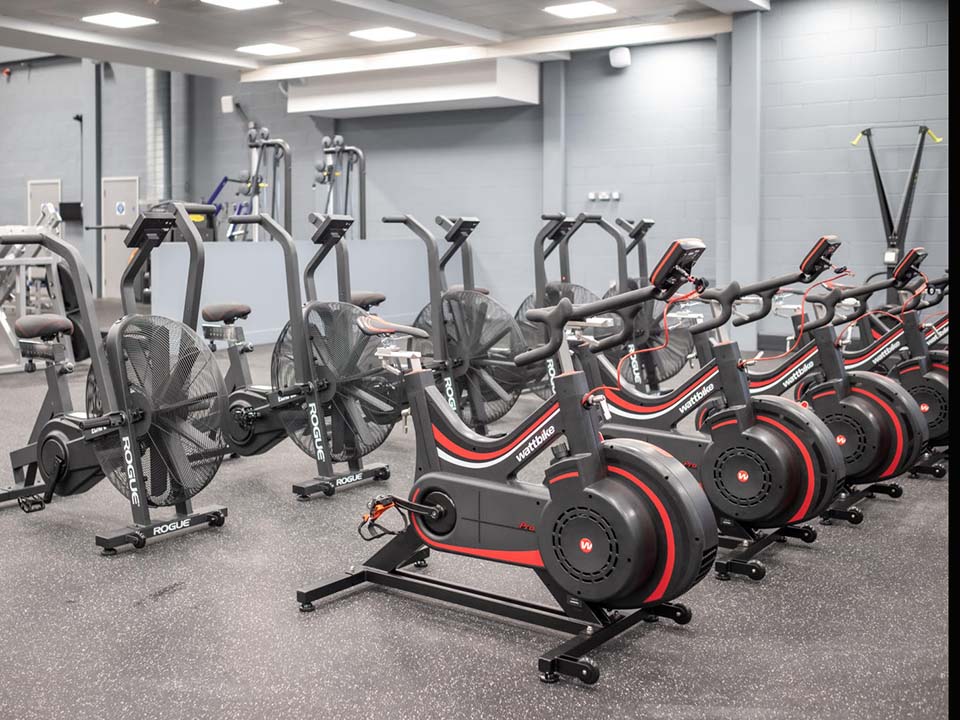 A row of spin bikes and wattbikes sit next to eachother.
