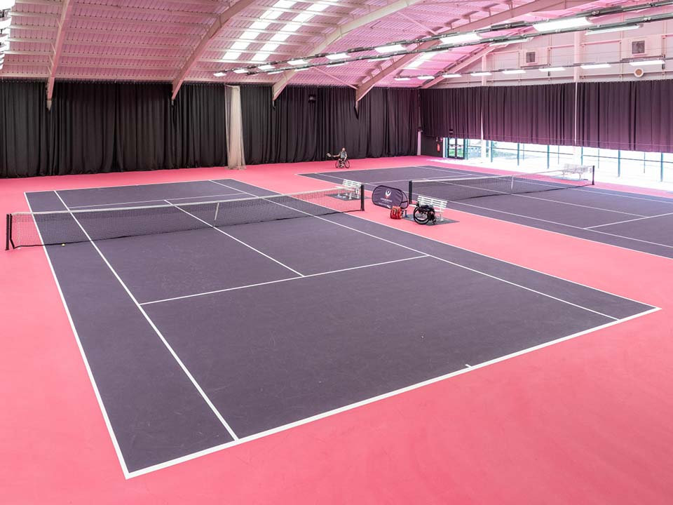 Purple courts sit next to each other in a hall.