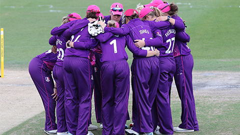 women cricketers having a team talk