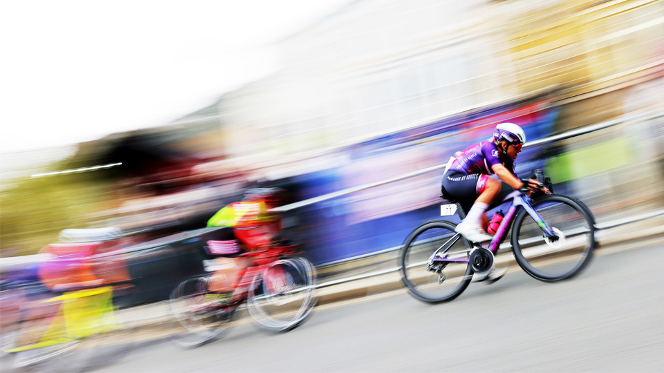 A photograph of two cyclists travelling at speed during a race.
