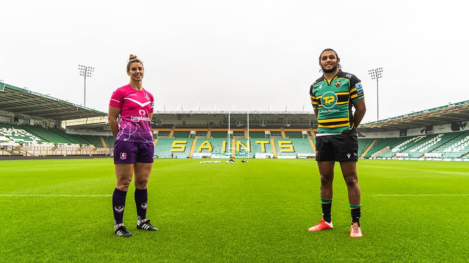 two players standing on a rugby pitch