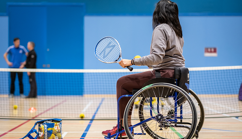 a woman wheelchair tennis player holding a racquet