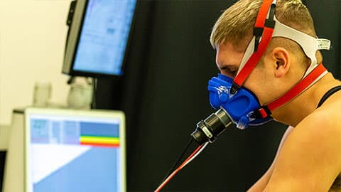 an athlete in a fitness testing lab with a mask over his nose and mouth