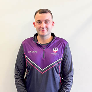 Jack is smiling for a photo wearing a Loughborough Sport quarter zip.