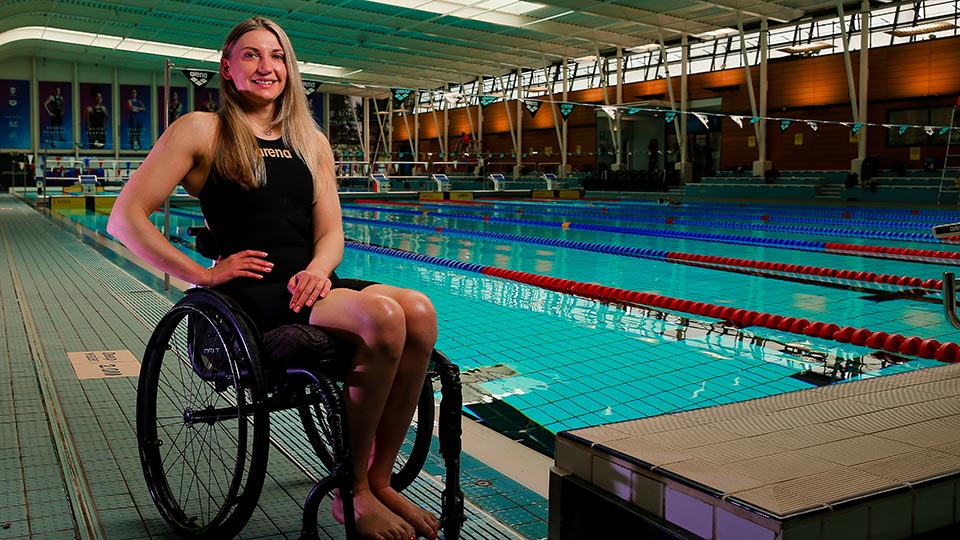A para swimmer in a wheelchair next to the pool