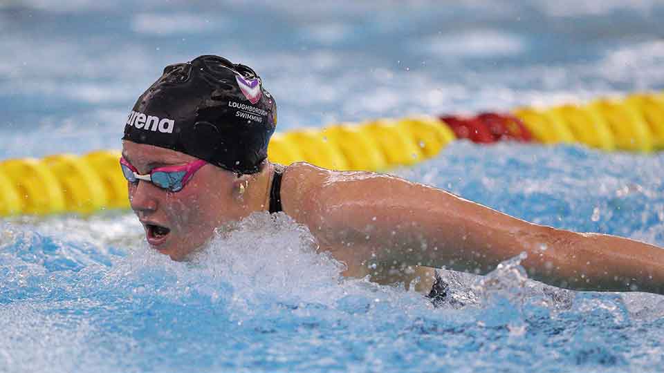 Fleur, mid stroke in a swimming pool wearing goggles and a swimming cap