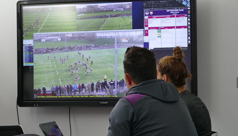 two people watching a TV screen