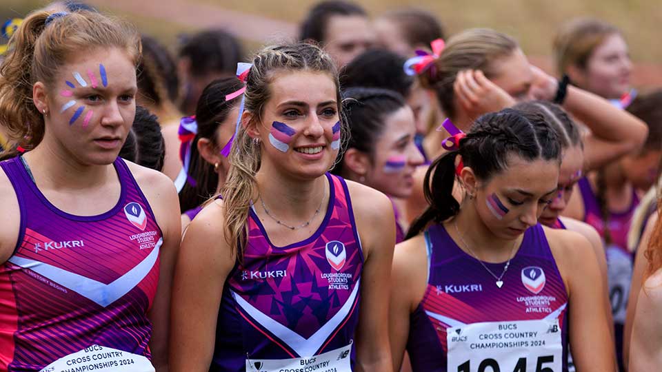 Athletes in Loughborough athletics kit with purple, pink and white face paint on at a BUCS cross country event