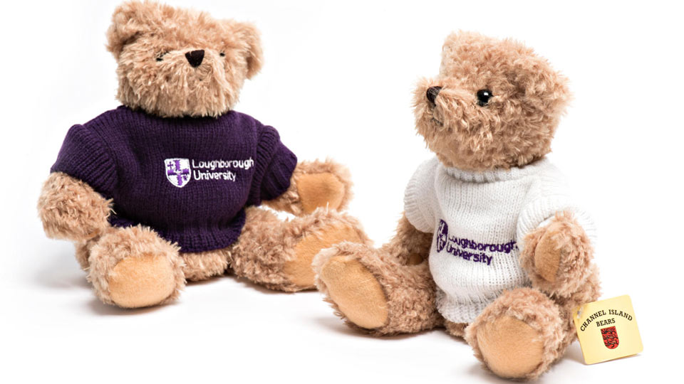 Two fluffy bears, one in a purple Loughborough jumper and one in white one.