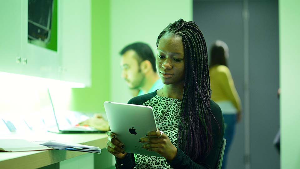 A student reading on an iPad.