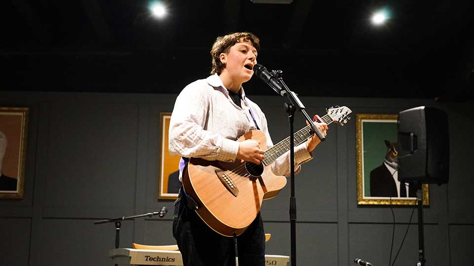 A performer singing and holding a microphone.