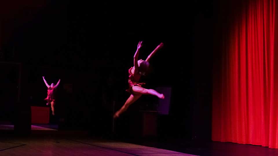 A dancer in the air on stage.