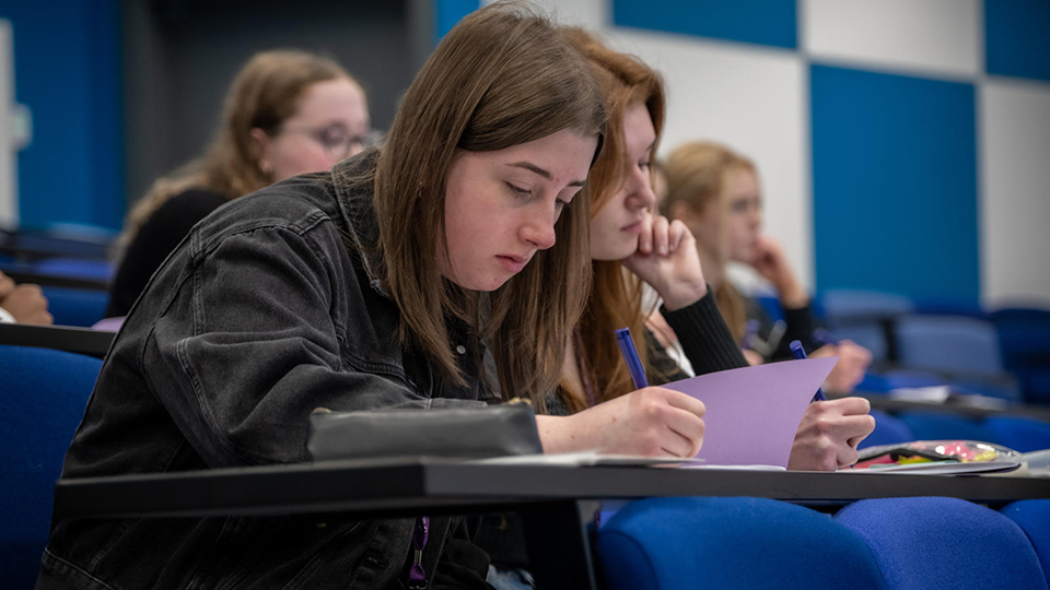 Student writing in book