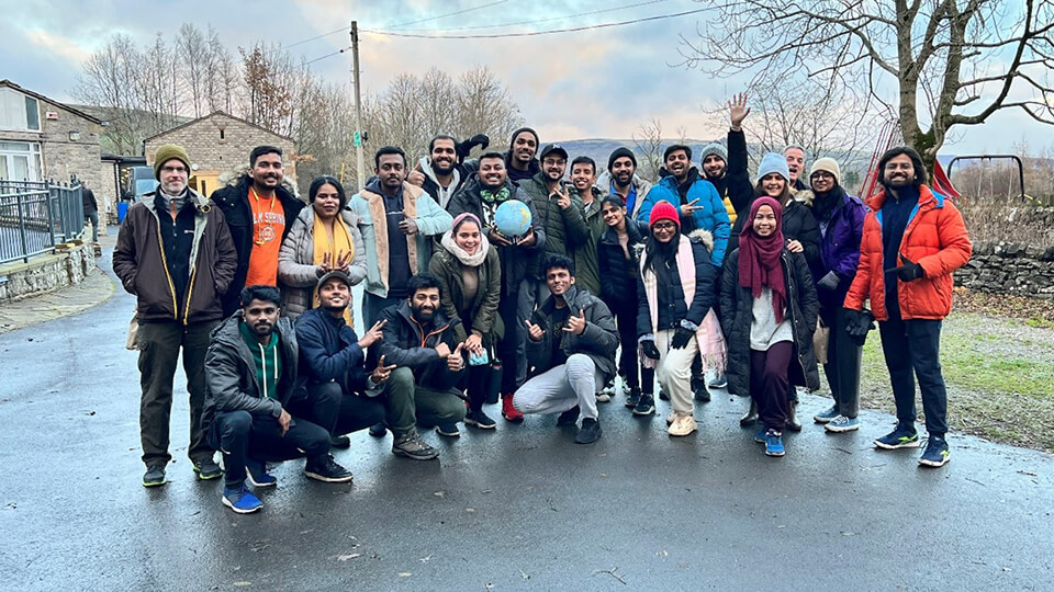 Group photo outdoors with a big group of students on a rainy day.