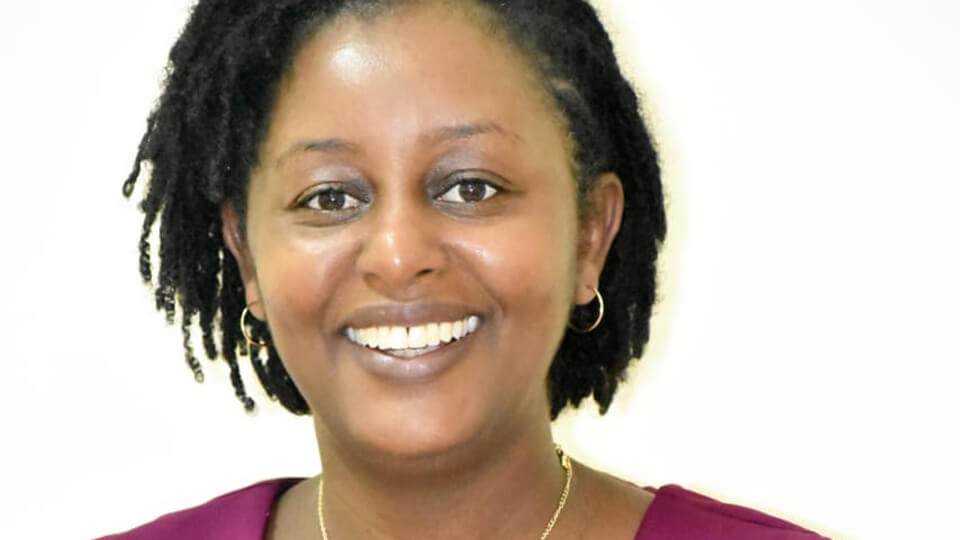 Woman smiling at the camera in front of a white background