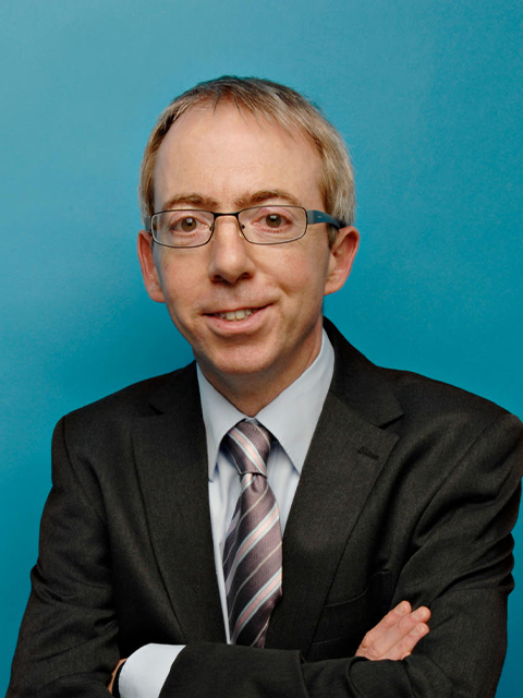 academic headshot of professor richard guilianotti against a blue background