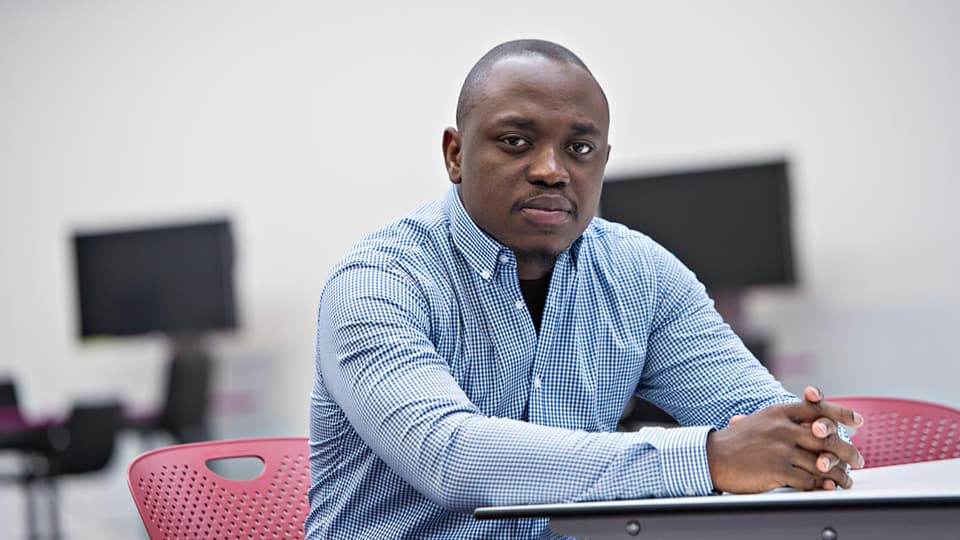 Abiodun sitting at a table.