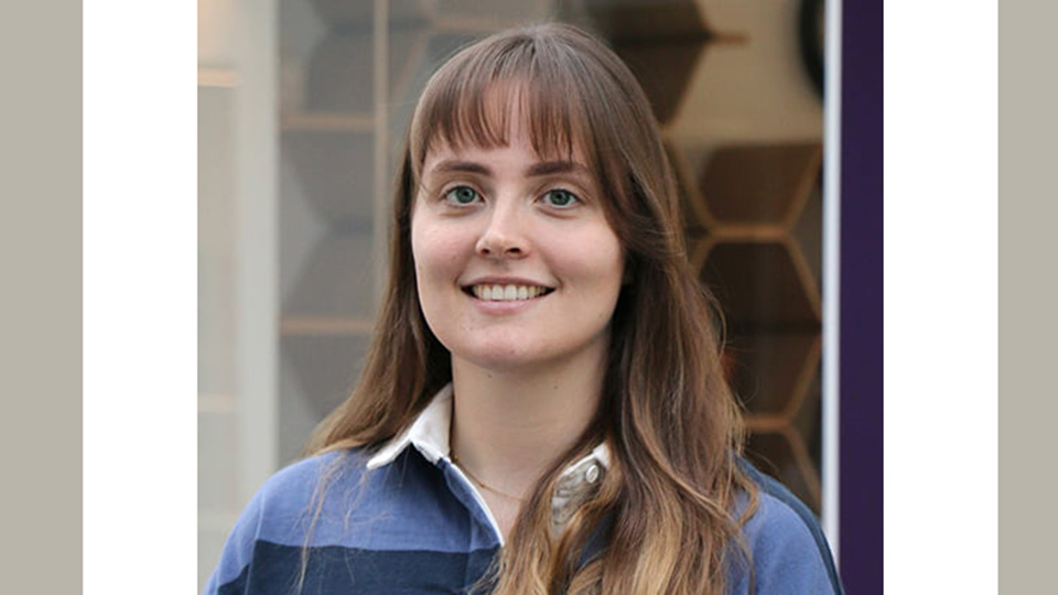 A lecturer smiling to camera