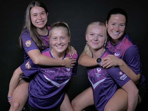 Chloe with three friends, all wearing Loughborough Sport t-shirts.