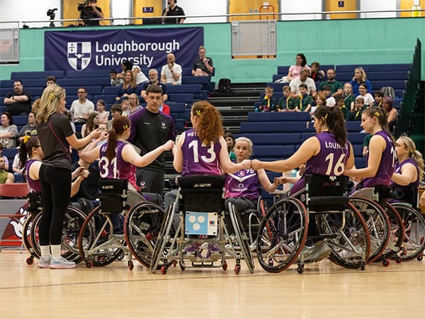 Members of the Loughborough Lightning Wheelchair Basketball team gathered in a huddle on court.