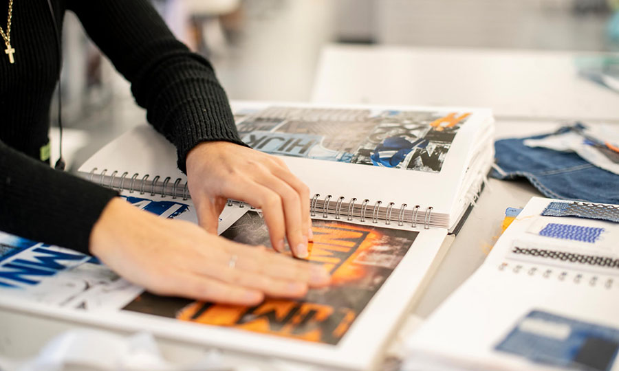 Someone sticking down pictures in a portfolio book