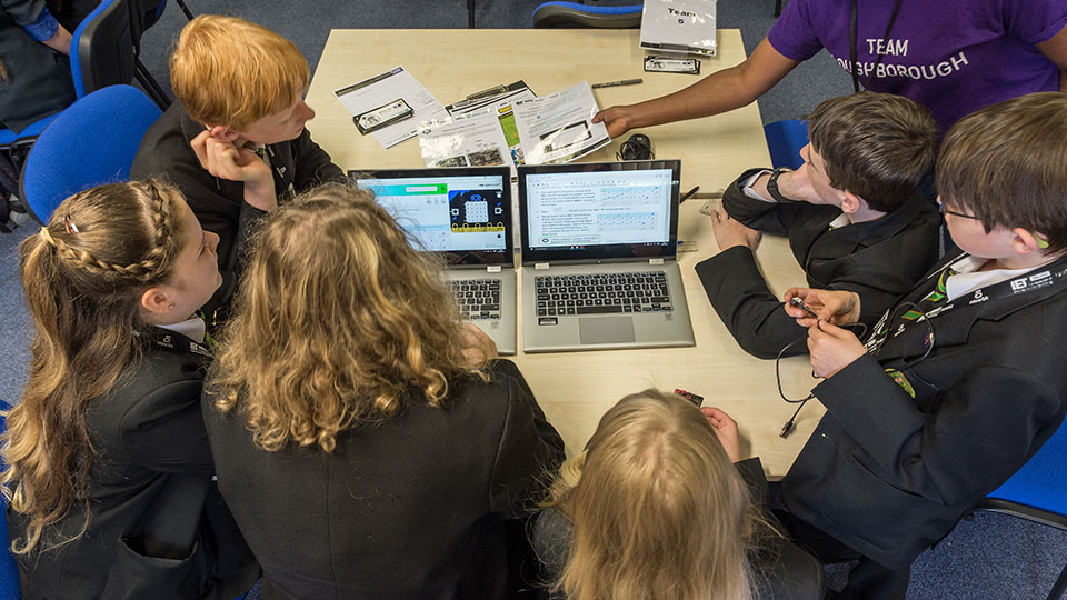 Realising opportunities. Children gathered around computers