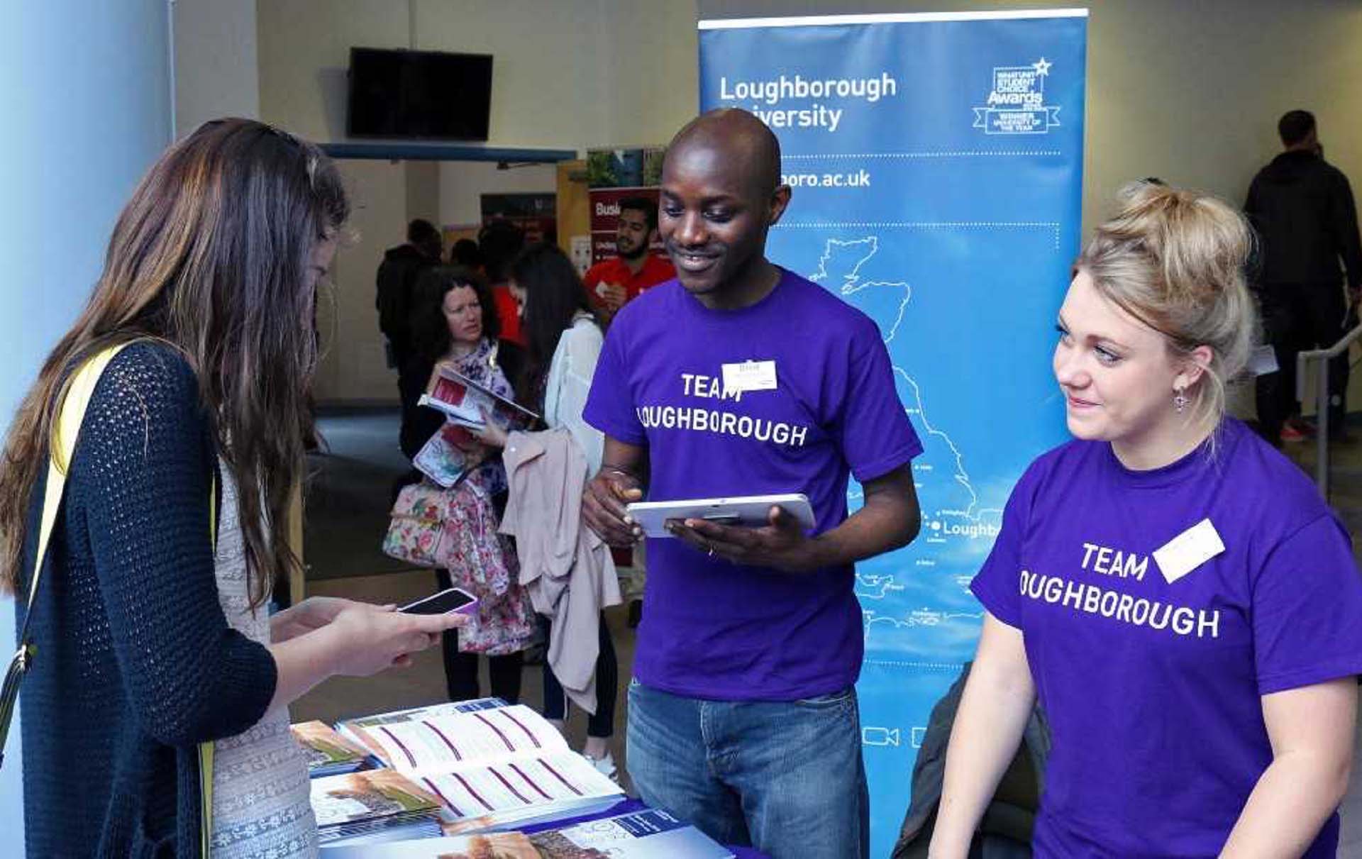 Two Loughborough Student Ambassadors helping a visitor at a Loughborough University open day.  
