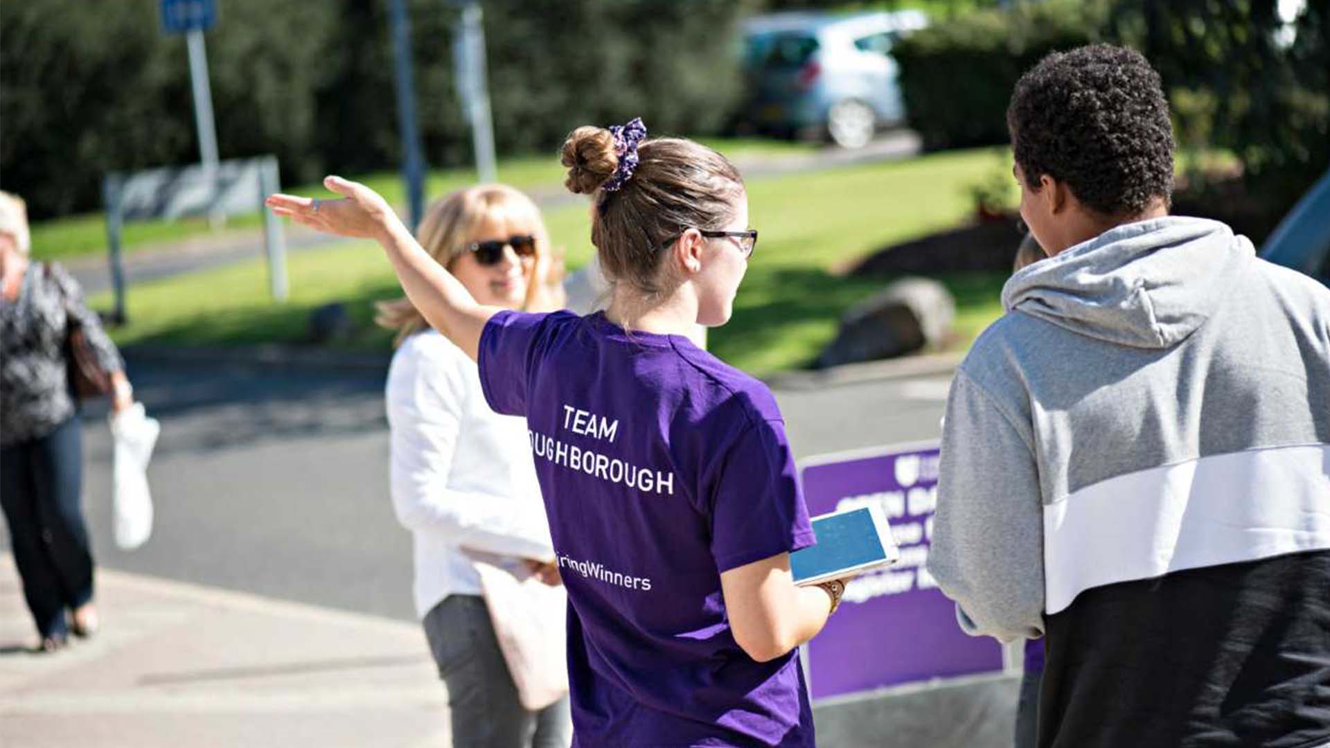 A Student Ambassador giving directions at a Loughborough University open day.