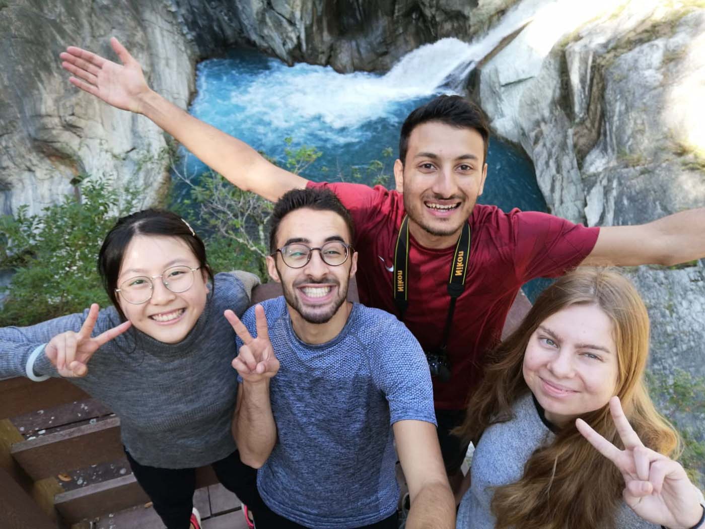 Simona and three friends in front of a waterfall.