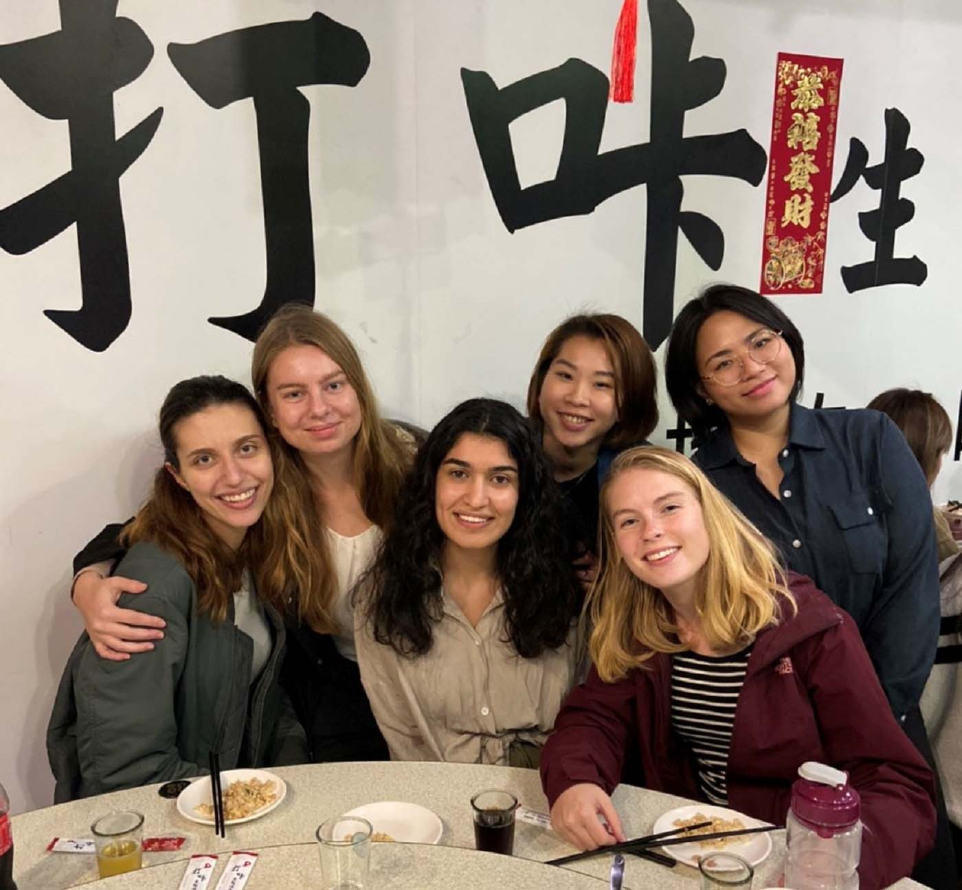 Simona and five friends at a restaurant. 