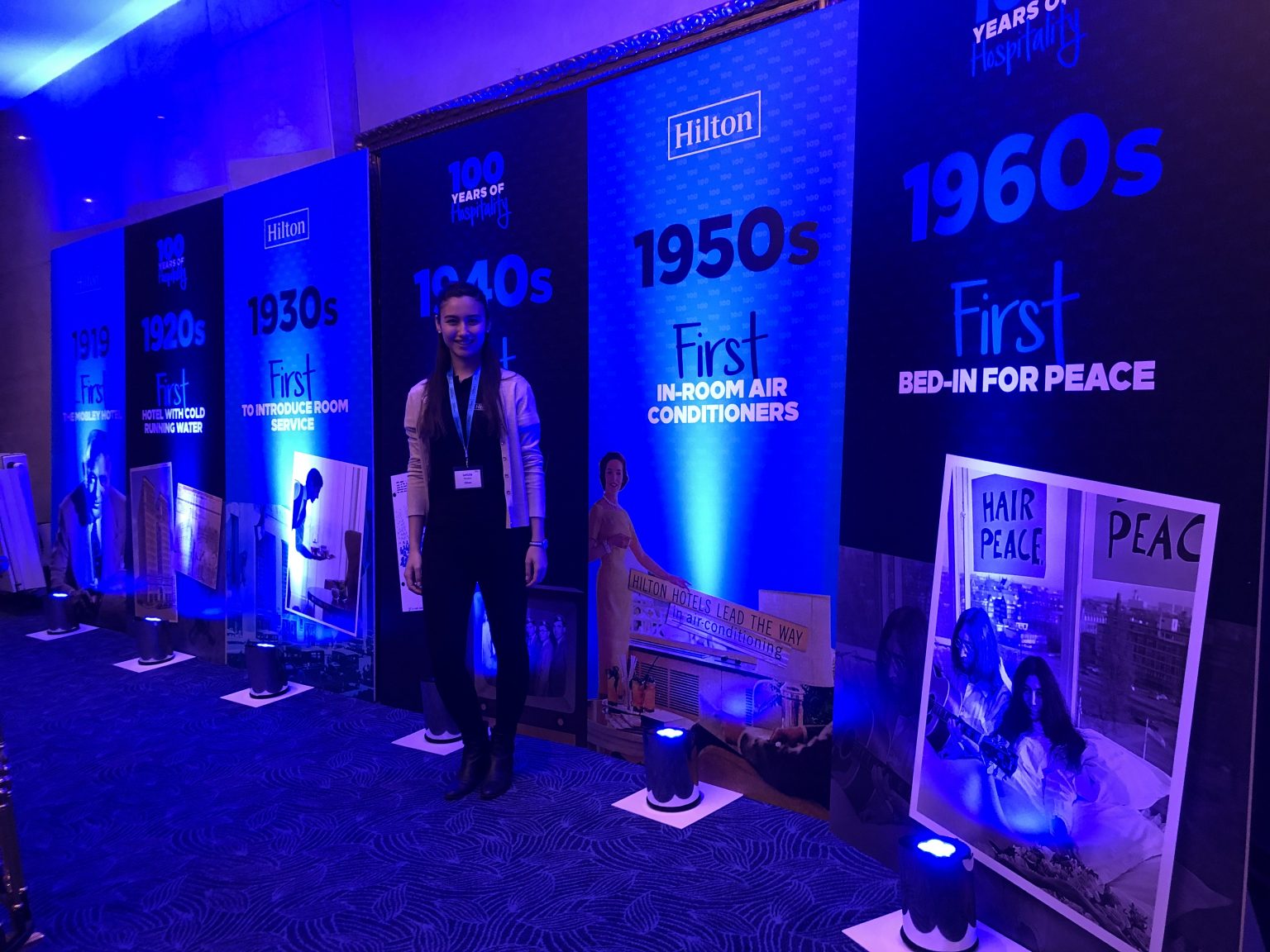 Lety in front of some Hilton banners at an event.  