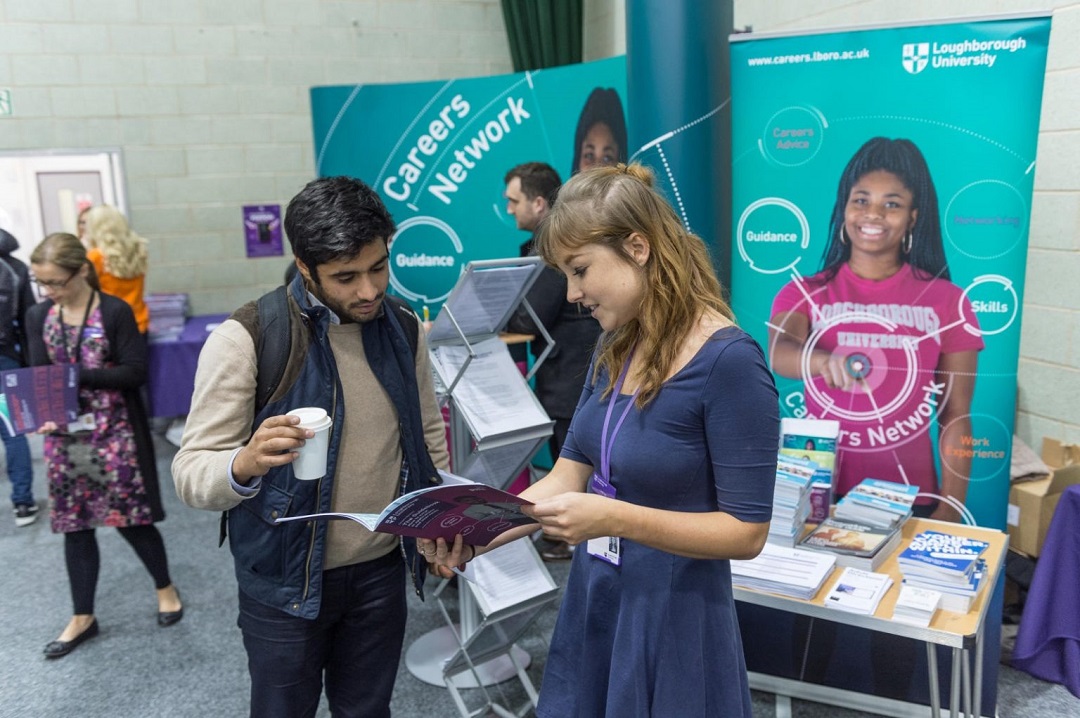 A student being shown a careers network booklet by a member of staff at one of Loughborough University’s careers events.