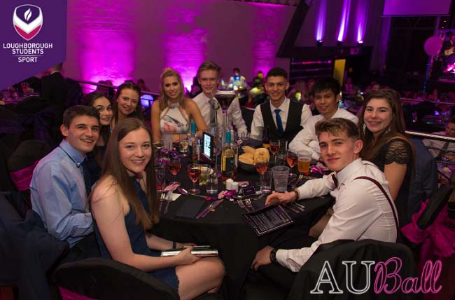 Eleanor and her friends sitting at a table at the Athletic Union ball. 