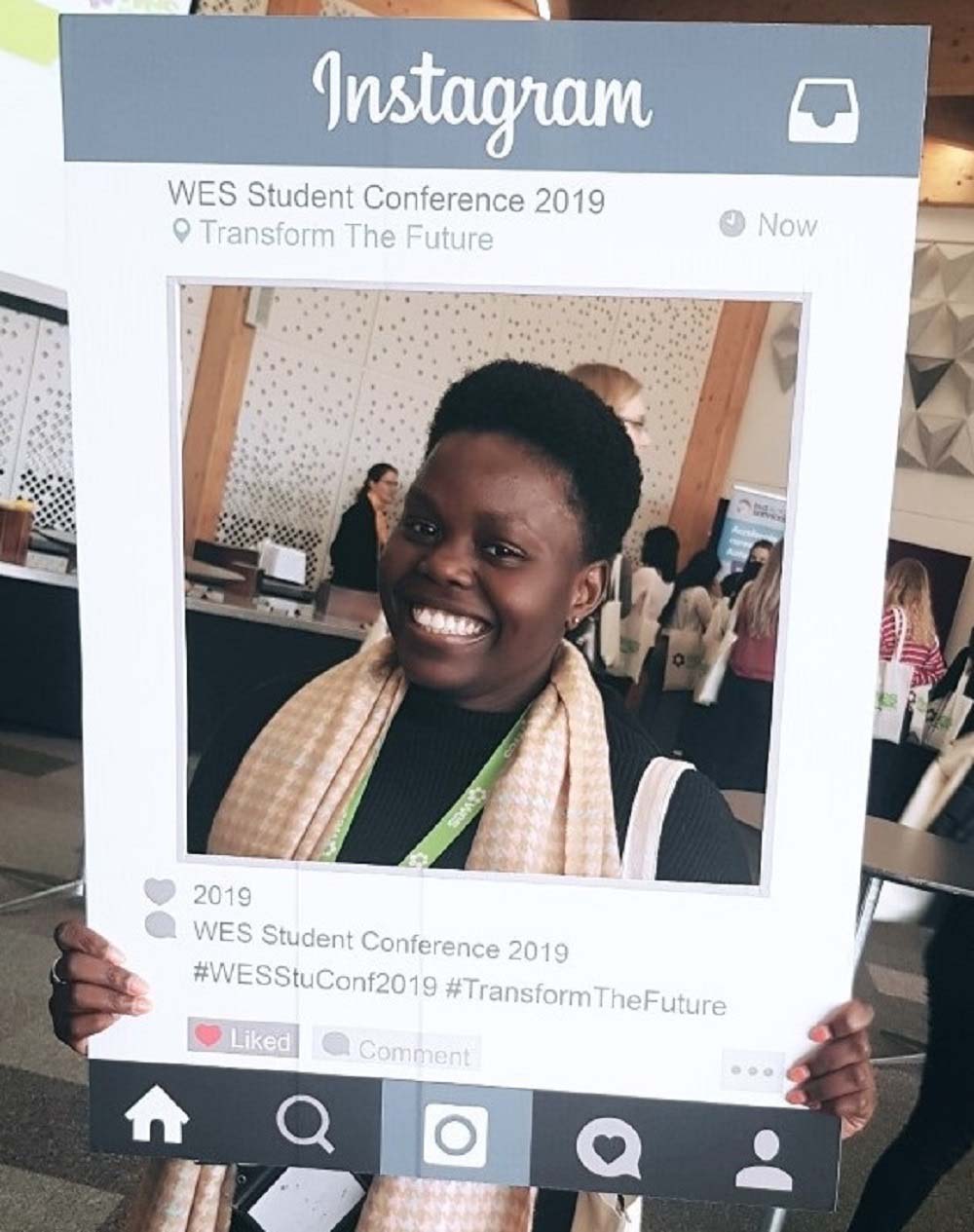 Seyi at the WES Student Conference 2019. She is holding a Instagram cut out which looks like she is a photo on the WES Instagram page. 