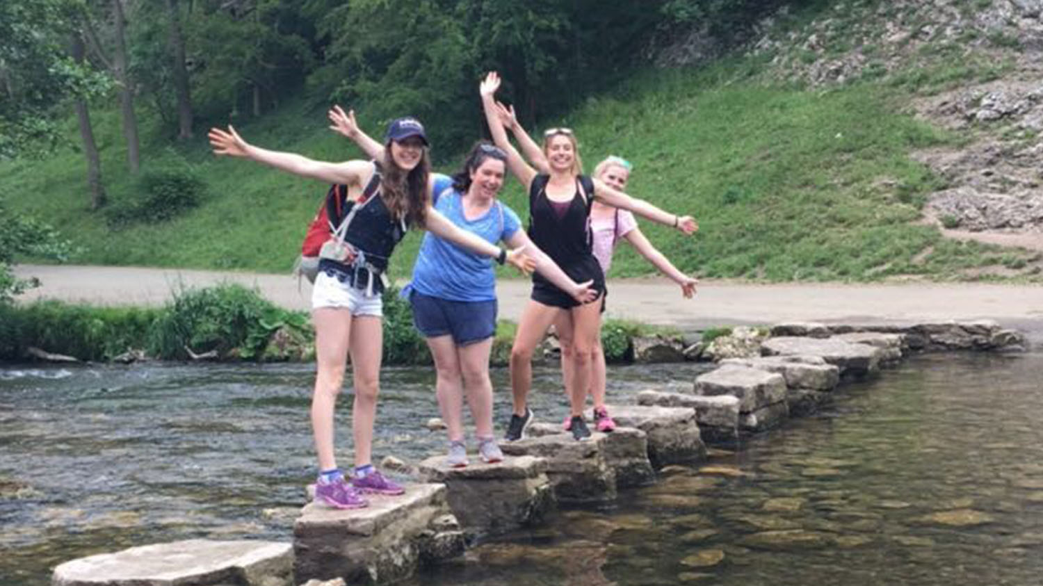 Imogen and three friends crossing a river. 