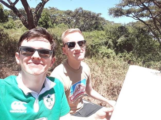 David wearing his Irish rugby top sitting next to a friend outside. 