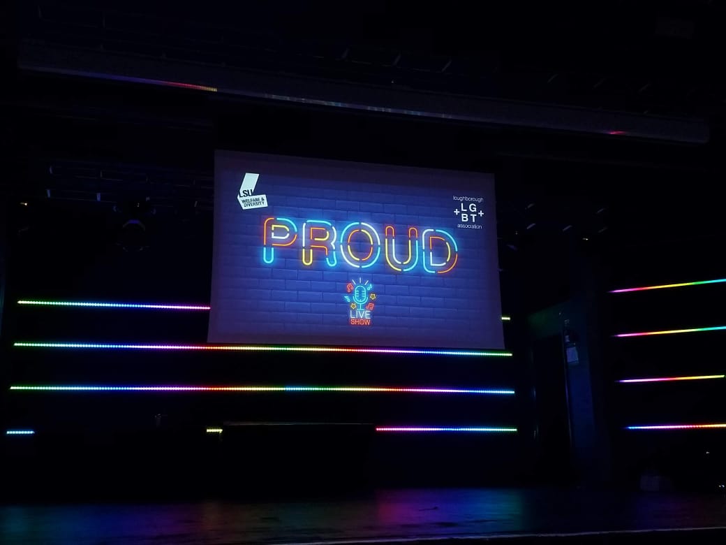 The word proud displayed on an LED screen in Room 1 in Loughborough Students Union. 