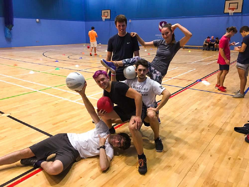 Anastasia and four friends posing for a photo at a dodgeball session in Holywell Sports hall. 