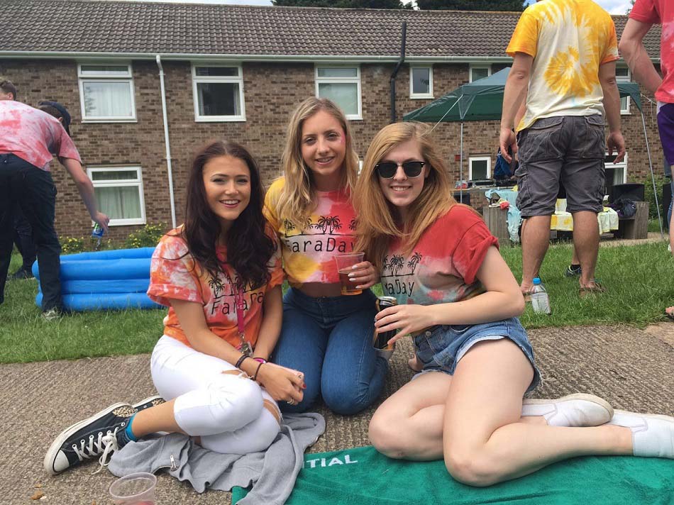 Niamh and two of her friends sitting on the ground at Faraday Hall day. 