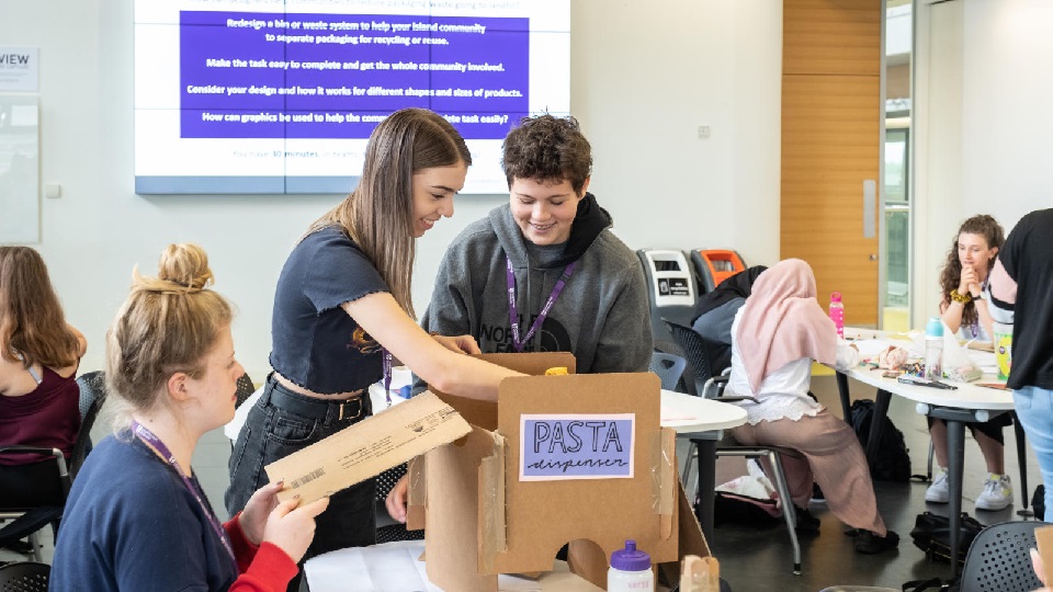 a group of people unpacking a large cardboard box