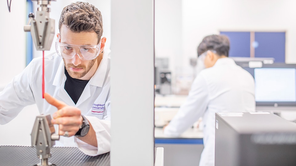 Two people working with equipment in the Materials Testing Laboratory within STEMLab at Loughborough University