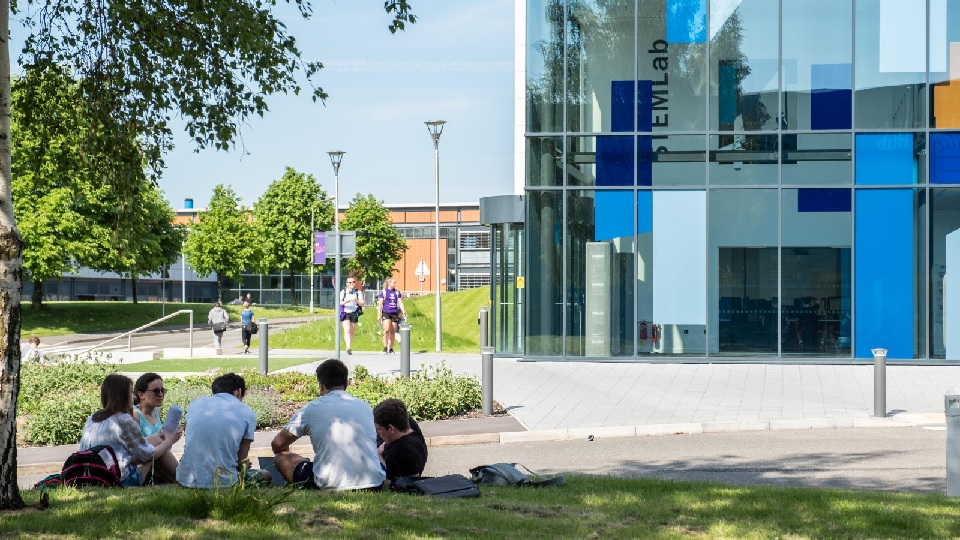 a group of people sitting on the ground near to STEMLab