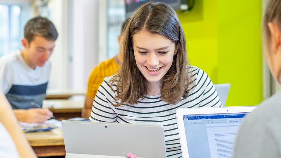 Students sat looking at their laptop screens.