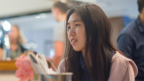 A female student chatting to a friend (out of the frame)