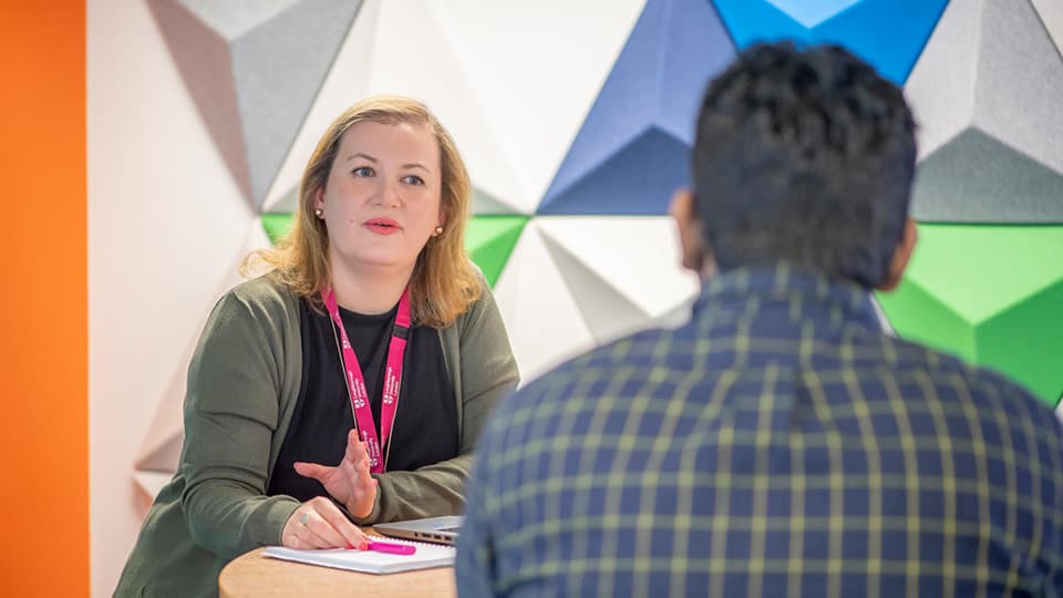 A student sat talking to a member of staff