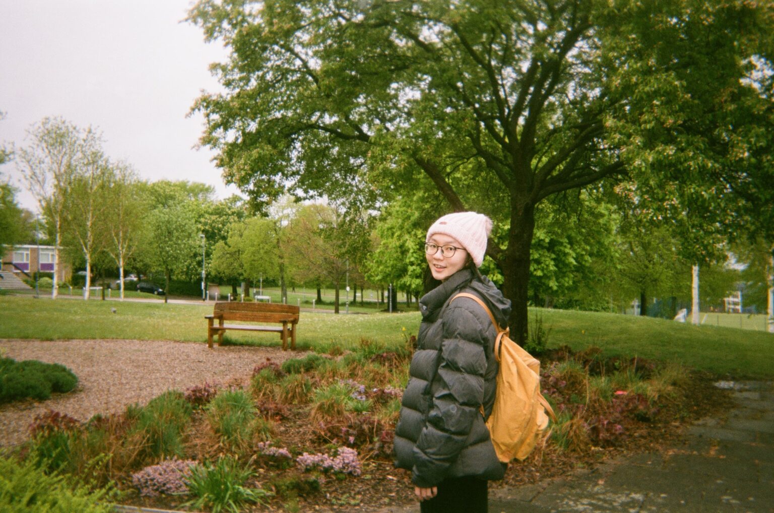 A female student standing in front of a tree in a park